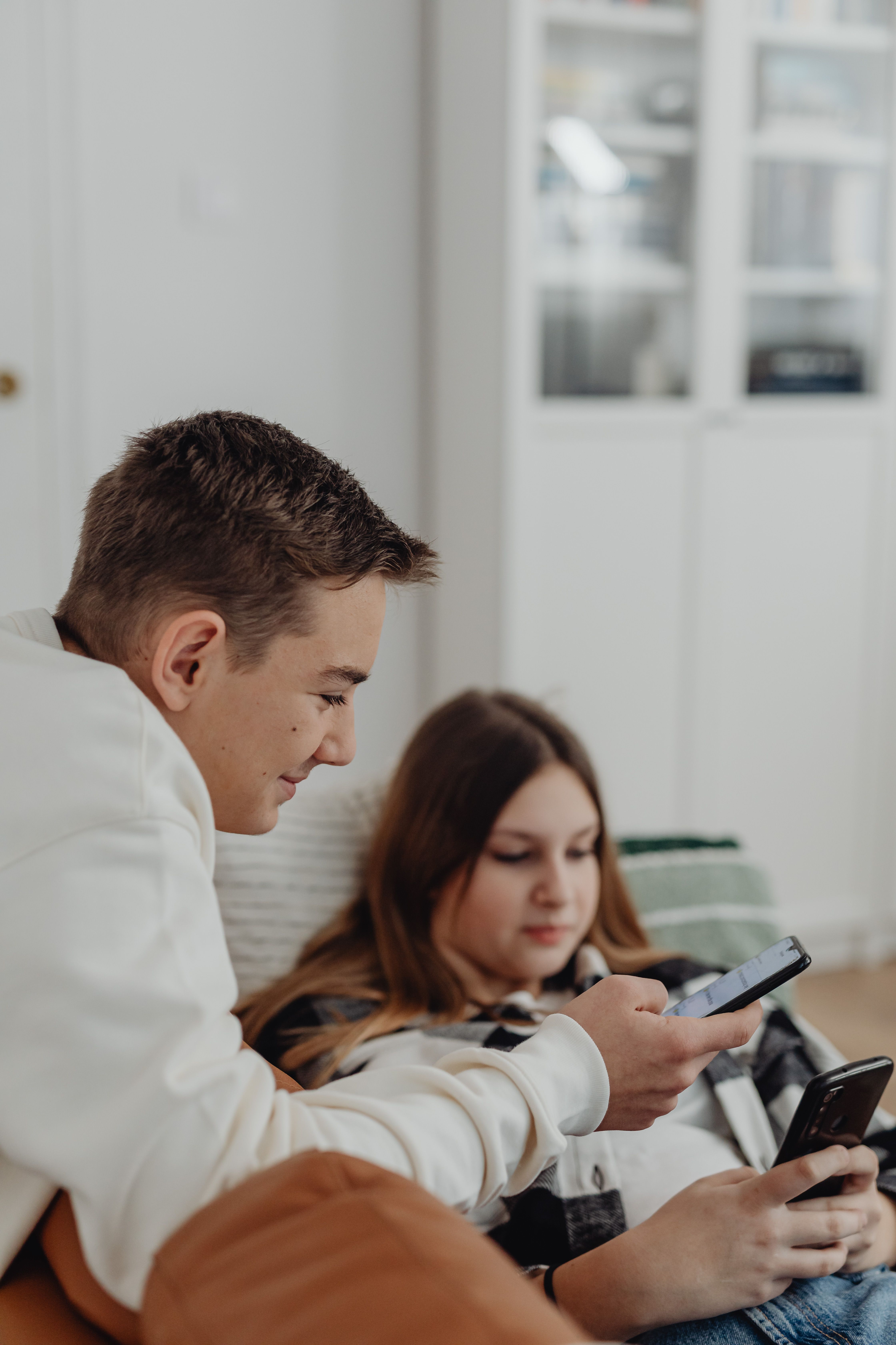 Casal usando o celular em um ambiente residencial claro e tranquilo